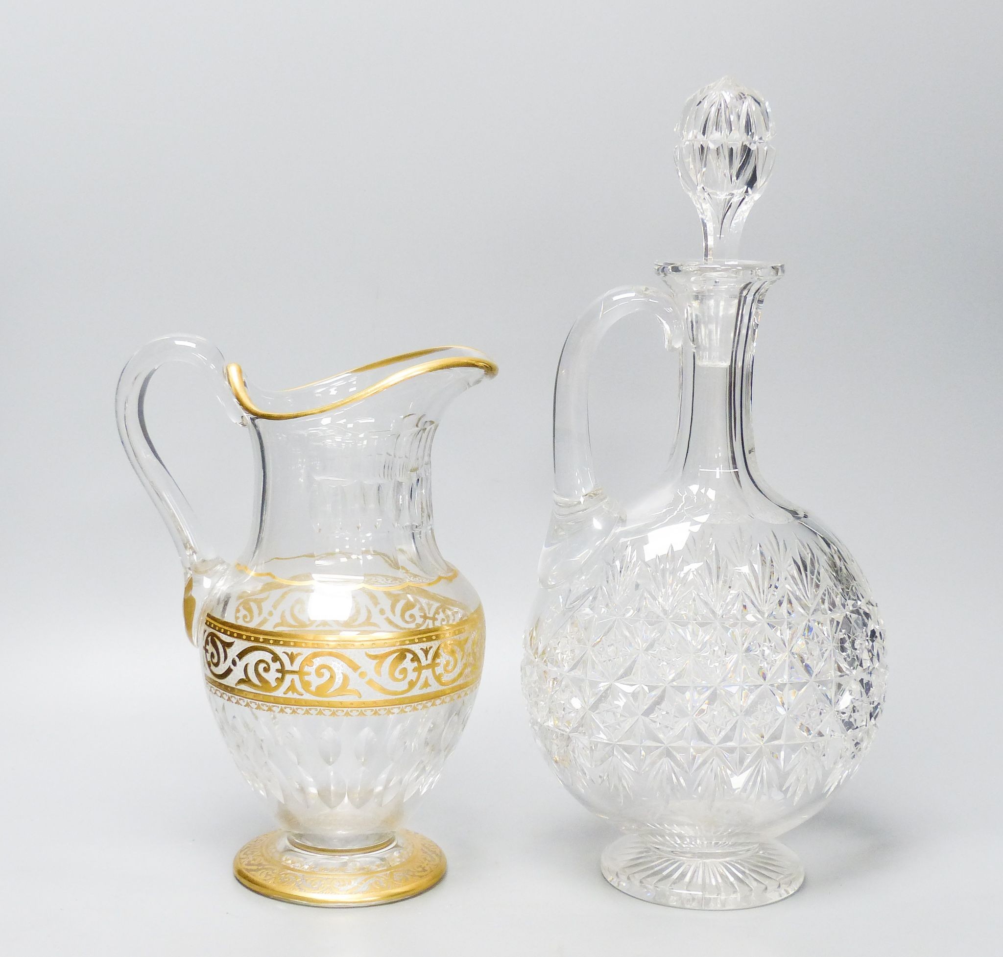 A Baccarat gilt and cut glass jug and a strawberry cut glass decanter and stopper, tallest 38 cm